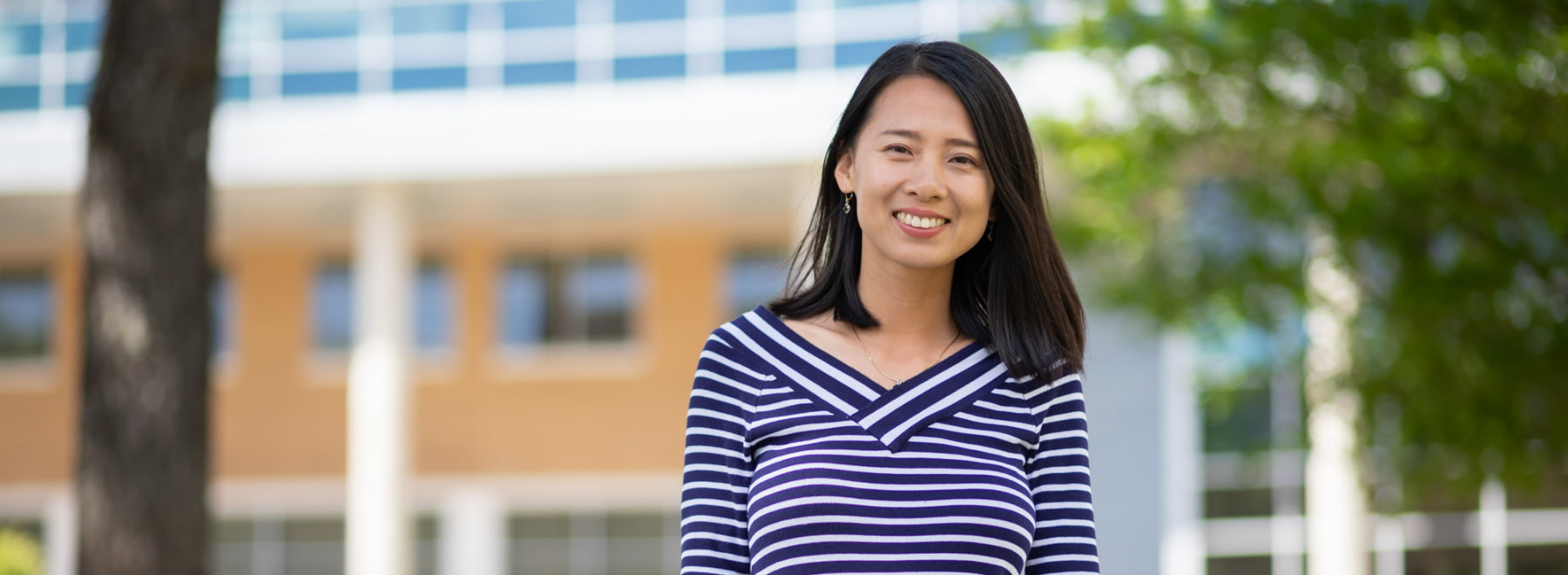 Female population health student poses in front of translational research building.